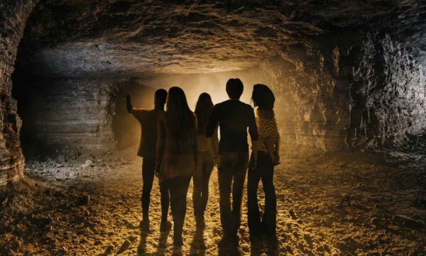 Five people looking through a cave