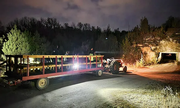 people on a trailer entering a cave